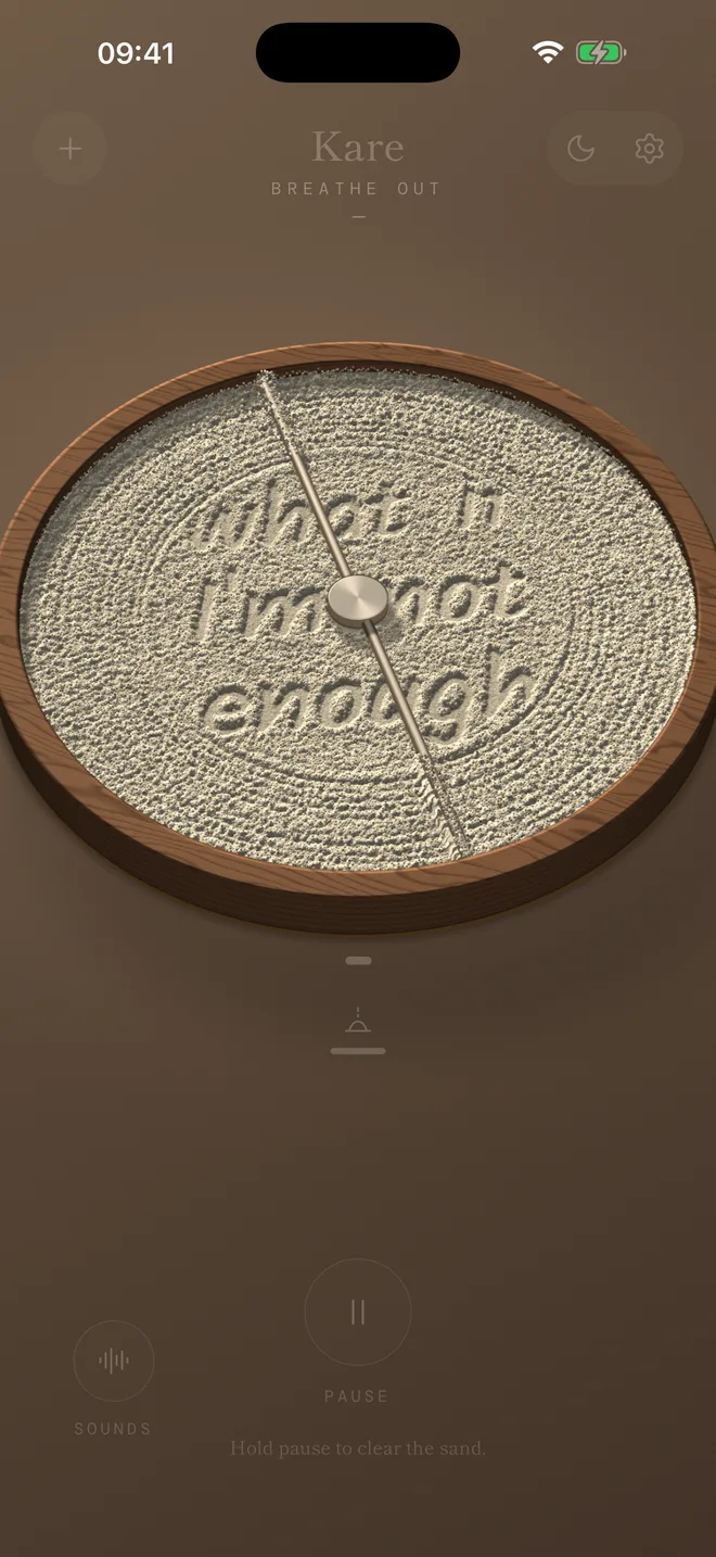 The words “what if I'm not enough” carved into ivory sand in a walnut tray